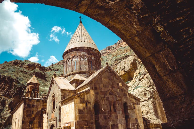 Entry through arch to cave monastery Geghard, Armenia. Armenian architecture. Pilgrimage place. Religion background. Travel concept. Church Astvatsatsin. Tourism industry. Entry through arch to cave monastery Geghard, Armenia. Armenian architecture. Pilgrimage place. Religion background. Travel concept. Church Astvatsatsin. Tourism industry