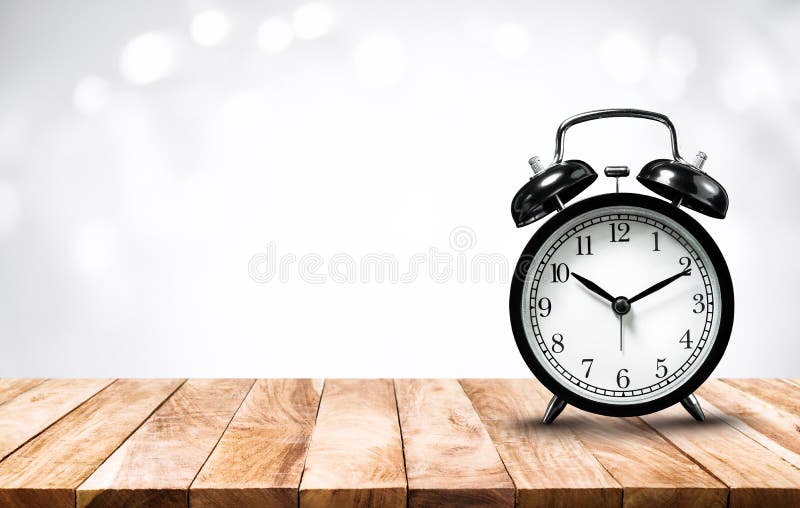 Wekker op houten lijstbovenkant met onduidelijk beeldsamenvatting bokeh F royalty-vrije stock foto Wekker op houten lijstbovenkant met onduidelijk beeldsamenvatting bokeh F royalty-vrije stock foto