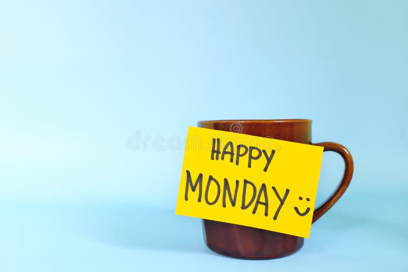 Welcome, hello and happy Monday concept. Selective focus of coffee cup with bright yellow paper note and written message isolated in blue background. Welcome, hello and happy Monday concept. Selective focus of coffee cup with bright yellow paper note and written message isolated in blue background.