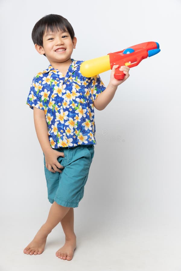 Welcome Thailand Songkran festival, Portrait of Asian boy wearing flower shirt smiled with water gun on white background stock photography Welcome Thailand Songkran festival, Portrait of Asian boy wearing flower shirt smiled with water gun on white background stock photography