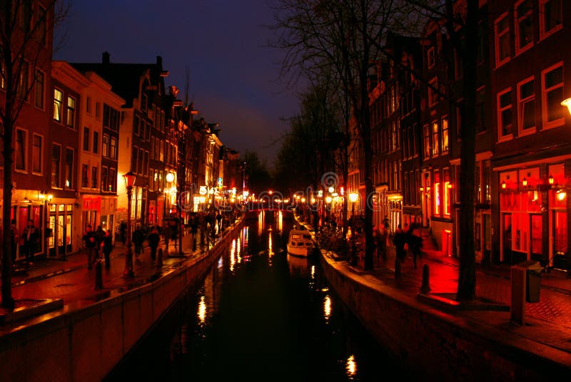 Night shot of a famous and touristy Red Light District spreading along a channel in downtown Amsterdam, the Netherlands. Night shot of a famous and touristy Red Light District spreading along a channel in downtown Amsterdam, the Netherlands.