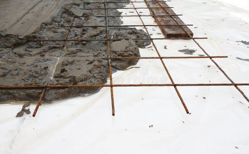 Welded wire mesh, or welded wire fabric, or weldmesh in cement concrete on the insulation foam board. Foundation reinforced stock images