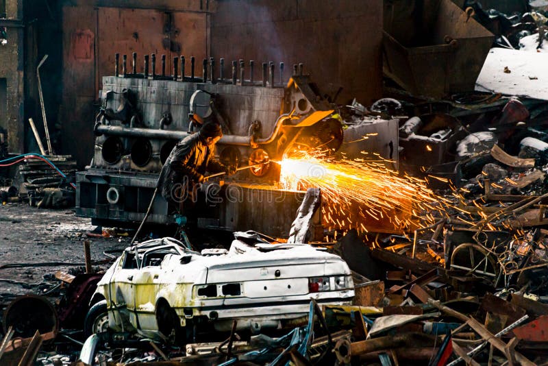 Welder with Soldering Iron Inside a Scrapyard. Editorial Photo Image