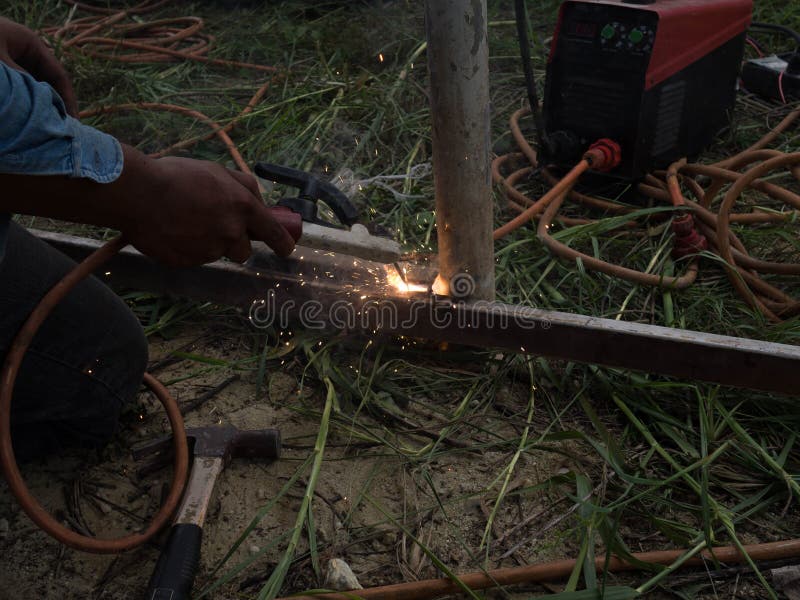 The Welder Using Electrode Welding the Steel Frame with Welding Machine