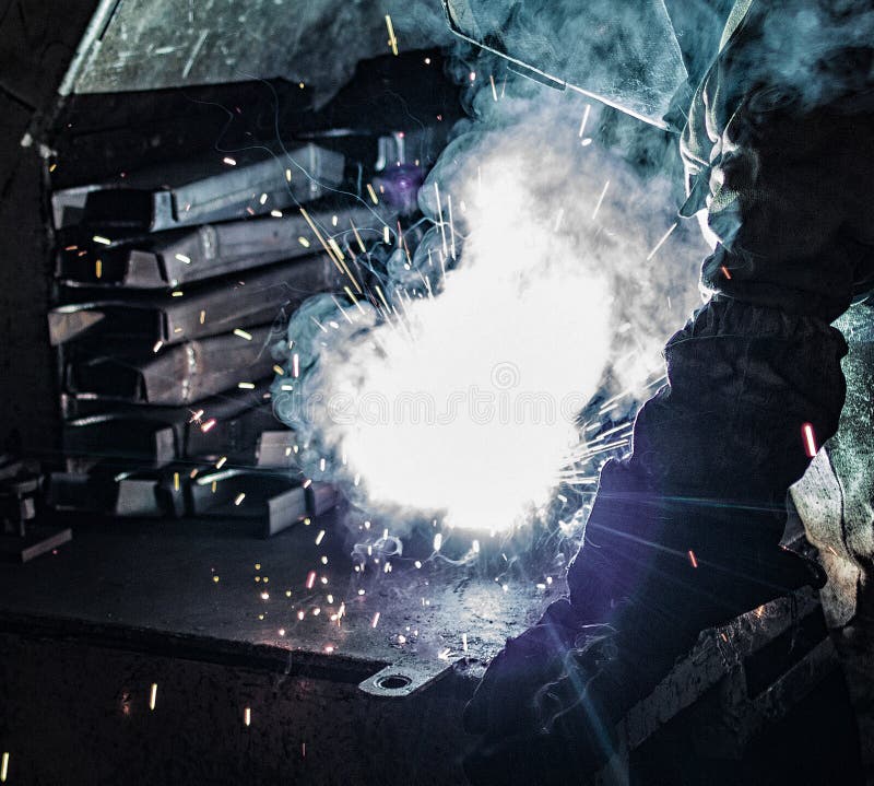 Welder welds metal parts, many sparks and fumes, welding, welding arc, bright flash, close-up, welding holder royalty free stock photos Welder welds metal parts, many sparks and fumes, welding, welding arc, bright flash, close-up, welding holder royalty free stock photos