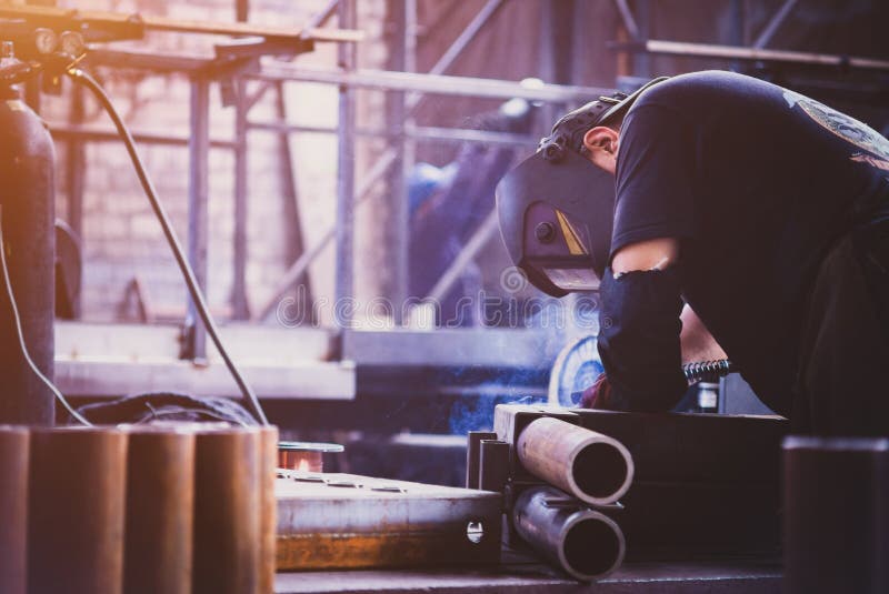 Welder Welding Angle Iron with Stick Electrode with Red and Blue