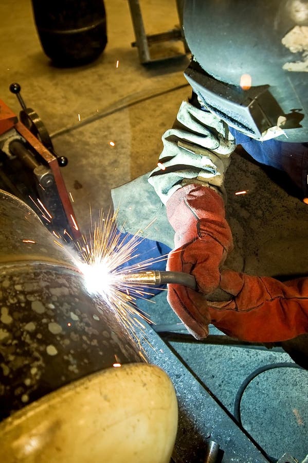 Pracovník oprava kovových součástí pomocí svařovací stroj.