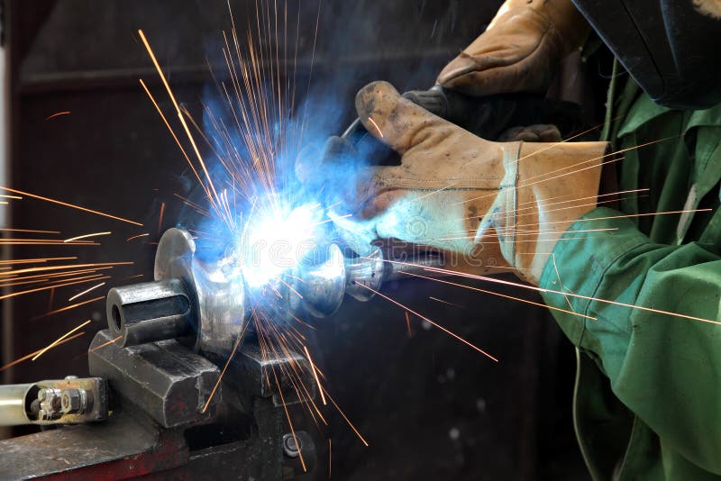 Welder with Soldering Iron Inside a Scrapyard. Editorial Photo Image