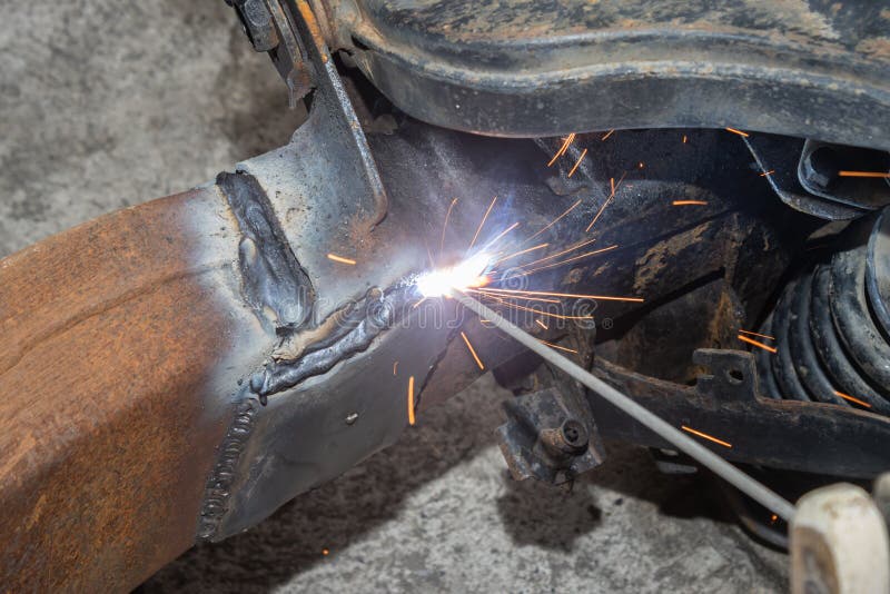Welding Man Welding Car Chassis in Garage by Electric Welding Torch in