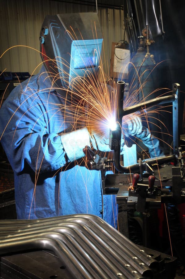 Welding a metal part in an industrial factory