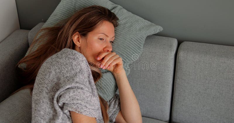 Thoughtful or confused disoriented middle age woman lie on sofa pillow. Concept of puzzled person thinking over unexpected difficult problem. High quality photo. Thoughtful or confused disoriented middle age woman lie on sofa pillow. Concept of puzzled person thinking over unexpected difficult problem. High quality photo