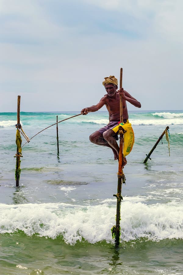 WELIGAMA, SRI LANKA - CERCA DO DEZEMBRO DE 2013: Pescador do pernas de pau foto de stock WELIGAMA, SRI LANKA - CERCA DO DEZEMBRO DE 2013: Pescador do pernas de pau foto de stock