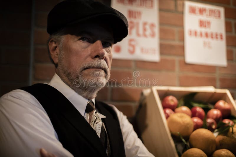 A well dressed unemployed man from the Great Depression of the 1930s peddling apples.