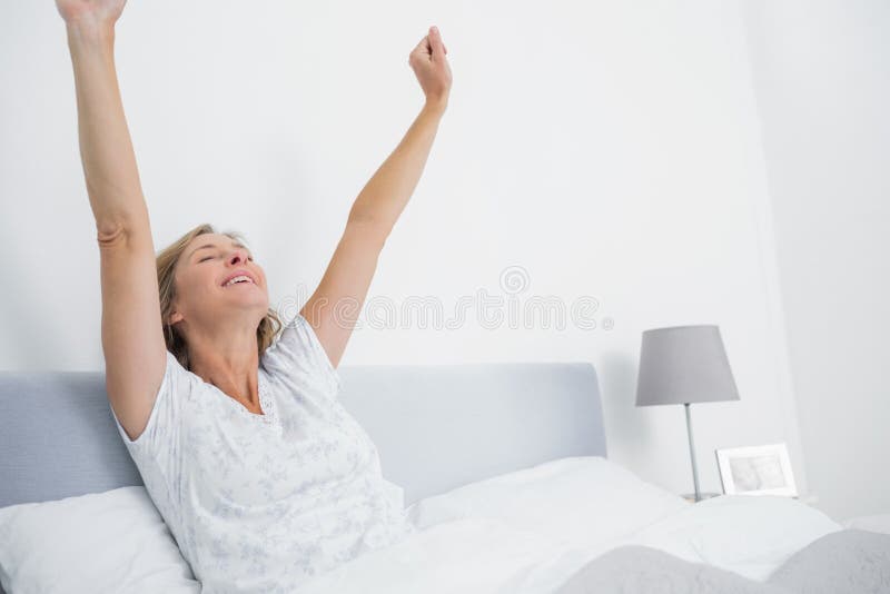 Well-rested Blonde Woman Enjoying Happy Morning, Stretching in Bed
