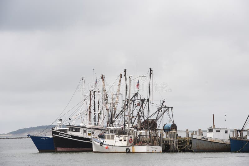 Boat in Wellfleet Harbor with Oystermen in the Background on Cape Cod