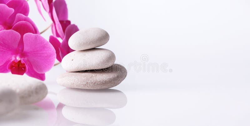 Wellness, relax, massage and wellbeing concept. Spa stones and orchid flower over white background