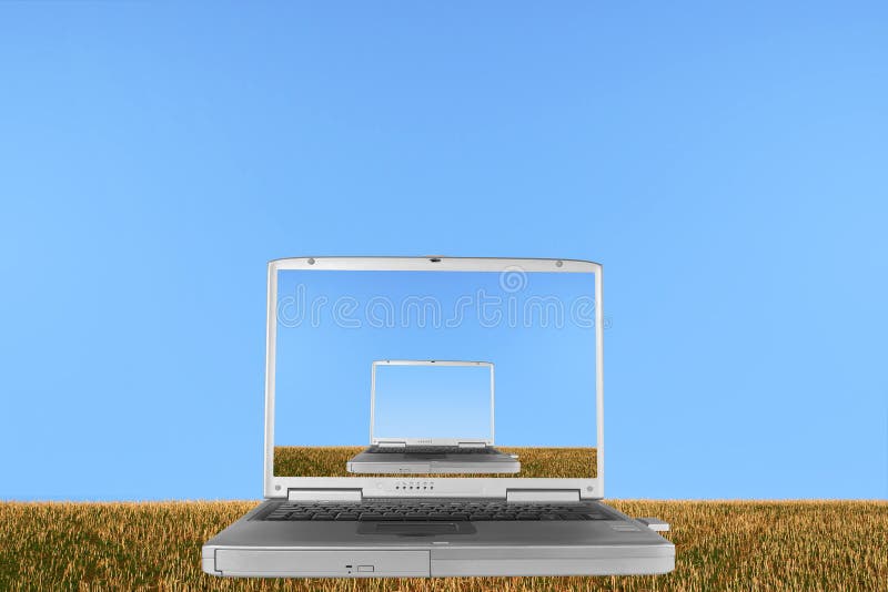 Silver laptop with the lid open against a hillside of rough stubble grass against a clear blue sky, with the whole image also mirrored within the laptops screen. Silver laptop with the lid open against a hillside of rough stubble grass against a clear blue sky, with the whole image also mirrored within the laptops screen.