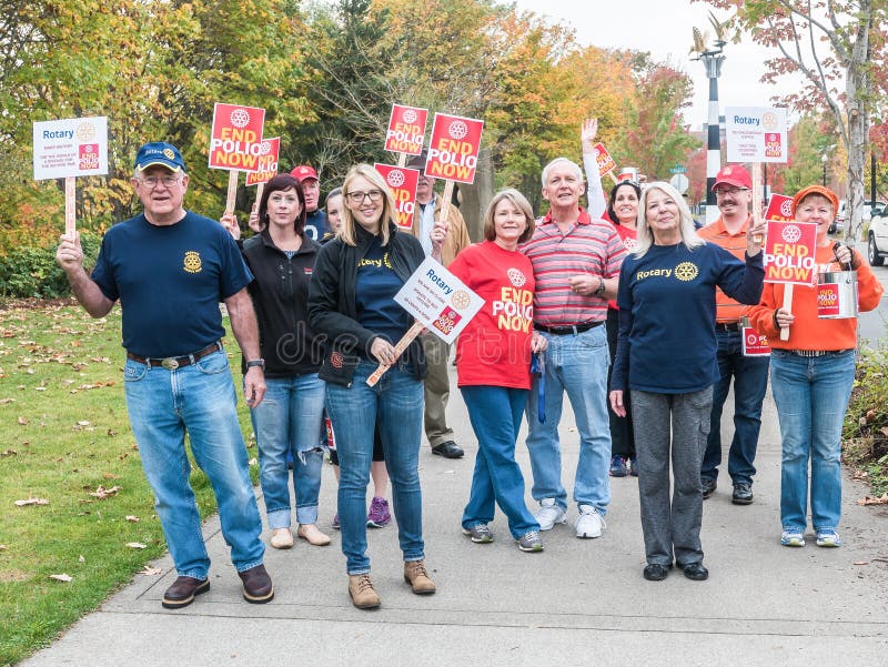 Corvallis, Oregon, October 24, 2015: World Polio Day marchers with signs from Rotary Club pause to smile for photograph. Corvallis, Oregon, October 24, 2015: World Polio Day marchers with signs from Rotary Club pause to smile for photograph