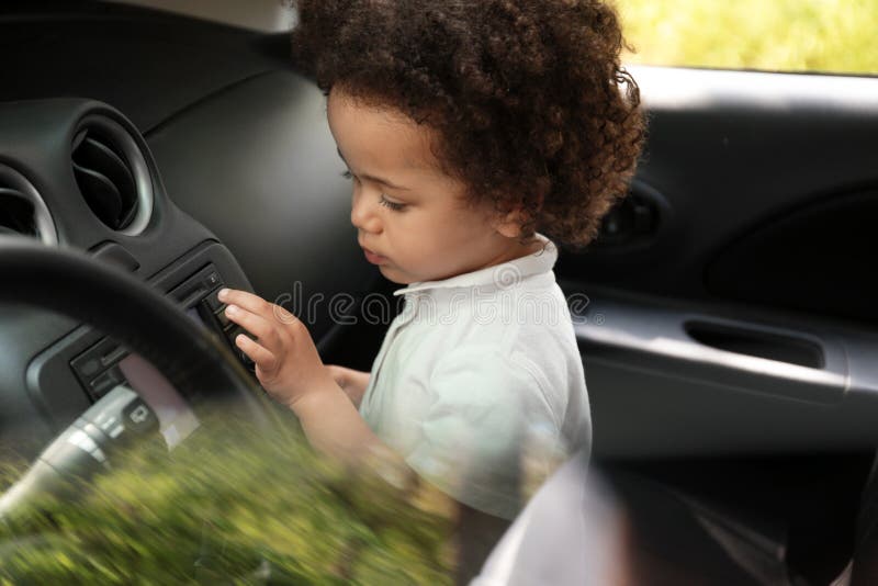 Wenig afro-amerikanisches Mädchen allein innerhalb des Autos stockfotografie Wenig afro-amerikanisches Mädchen allein innerhalb des Autos stockfotografie