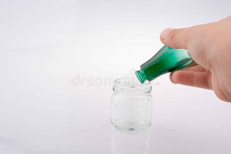 Wenig bunte Flasche ?ber einem Glas lizenzfreie stockbilder Wenig bunte Flasche ?ber einem Glas lizenzfreie stockbilder