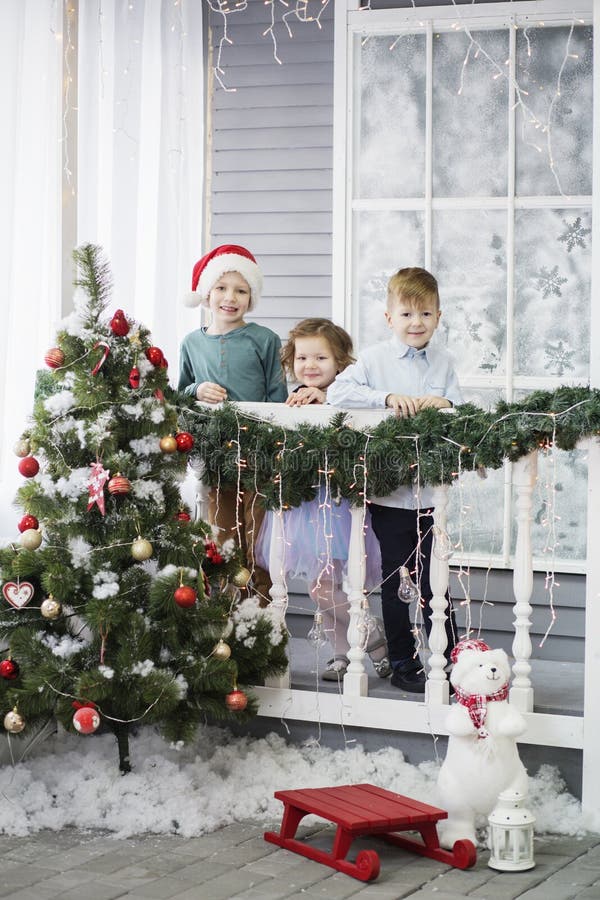 Wenig Kinder in Erwartung des neuen Jahres und des Weihnachten Drei Kleinkinder haben Spa? und spielen nahe Weihnachtsbaum stockbilder