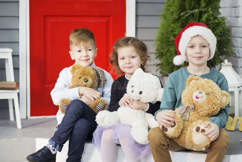 Wenig Kinder in Erwartung des neuen Jahres und des Weihnachten Drei Kleinkinder haben Spa? und spielen mit Teddyb? ren stockfotos