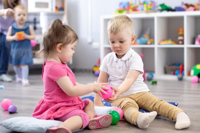 Wenig Kleinkindjunge und ein Mädchen, das zusammen im Kindertagesstättenraum spielt Vorschulkinder in der Tagesstätte