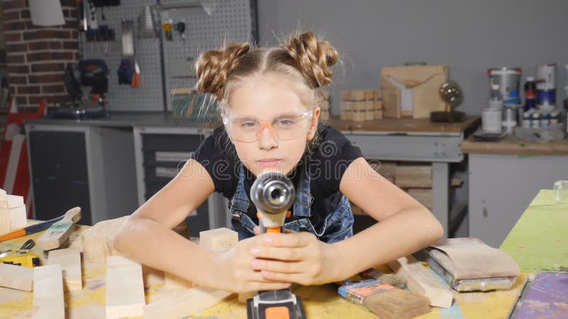 Wenige jährigen Hände des Mädchens 10 und eines Bohrgeräts herein Langsame Bewegung Junger hübscher Mädchenerbauer hält bohren in stock footage