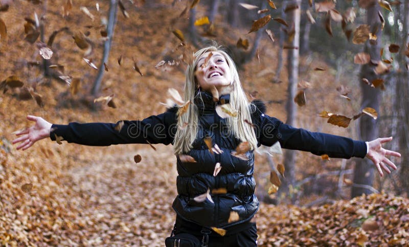 Werfende Herbstblätter des jungen Mädchens lizenzfreies stockfoto Werfende Herbstblätter des jungen Mädchens lizenzfreies stockfoto