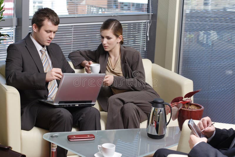 Werkende Bedrijfsmensen die in het bureau en het spreken zitten royalty-vrije stock afbeelding Werkende Bedrijfsmensen die in het bureau en het spreken zitten royalty-vrije stock afbeelding