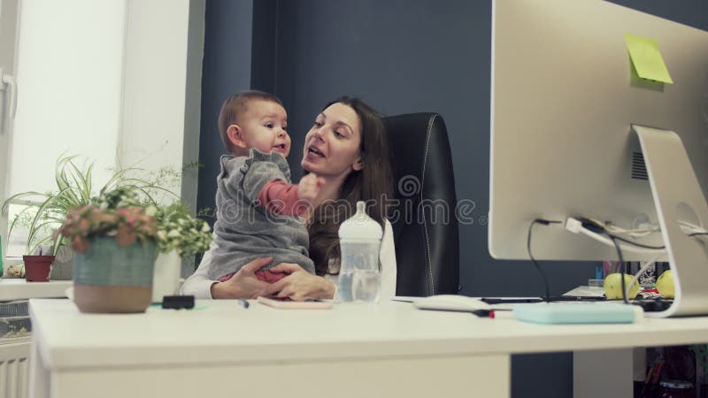 Werkende moeder met peuter op baby vriendschappelijk kantoor, het werk sucsessful vrouwelijk ondernemers modern moederschap