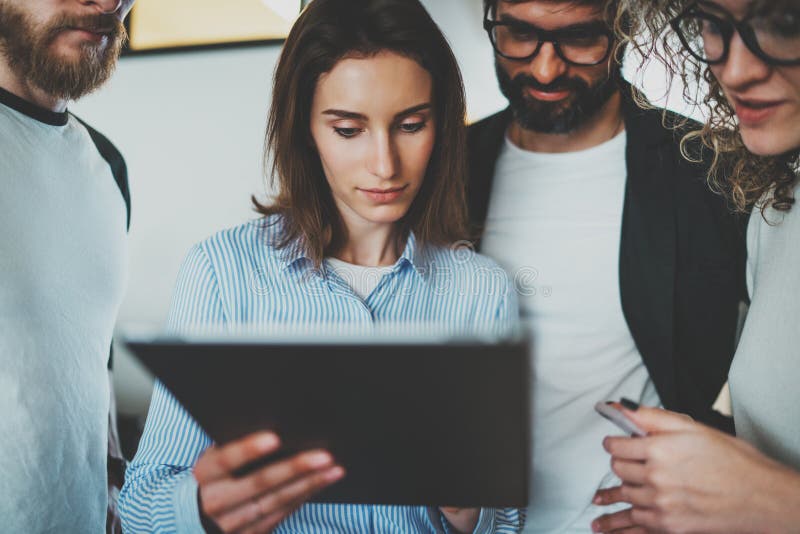 Werkende procesfoto Groep jonge medewerkers die elektronische gadgets gebruiken samen bij moderne bureauzolder stock afbeeldingen Werkende procesfoto Groep jonge medewerkers die elektronische gadgets gebruiken samen bij moderne bureauzolder stock afbeeldingen