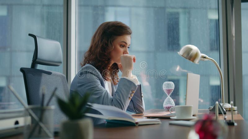 Werkneemster die laptop sms't, tafel op kantoor dicht. vrouwelijke baas werkt