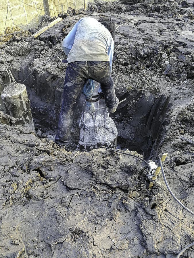 Werknemers maken gebruik van elektrische boor om betonnen palen in een groot gat in de bouwnijverheid te versieren de stapel voor stock foto Werknemers maken gebruik van elektrische boor om betonnen palen in een groot gat in de bouwnijverheid te versieren de stapel voor stock foto