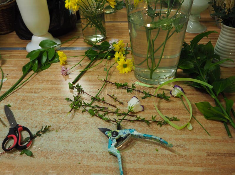 Werkplaats van bloemist met schaar en bloemen op houten lijst royalty-vrije stock afbeeldingen Werkplaats van bloemist met schaar en bloemen op houten lijst royalty-vrije stock afbeeldingen