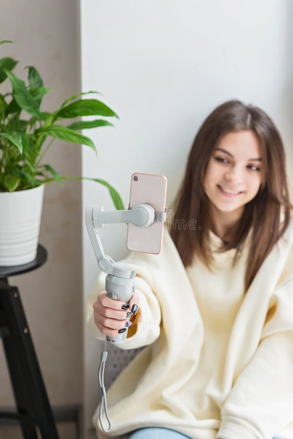 Wesoła nastolatka w domu gra przed kamerą dla vloga. młoda kobieta pracująca jako bloger nagrywająca wideo samouczek dla obraz stock