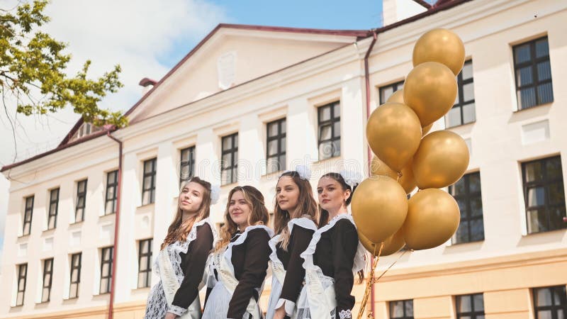 Wesołe rosyjskie dziewczęta kończą szkołę z balonami pomarańczowymi w ostatnim dniu szkoły. zdjęcia stock