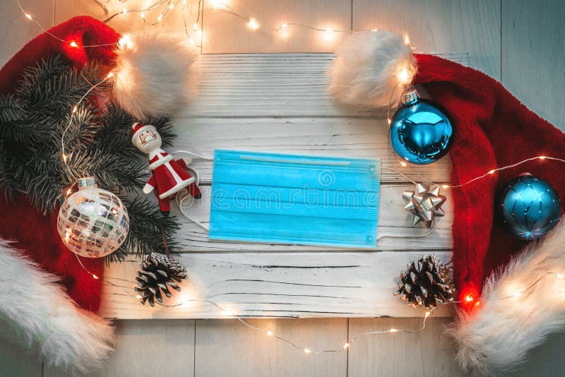 Wesołe świąteczne święta tło kapelusze santa i ozdoby z maską chirurgiczną do koronawirusa fotografia stock