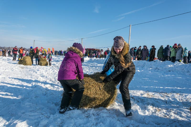 City of Uglich, Yaroslavl region, Russia - 10.02.2018: Merry competition for hay carrying at the festival Winter fun in Uglich, 10.02.2018 in Uglich, Yaroslavl region, Russia. City of Uglich, Yaroslavl region, Russia - 10.02.2018: Merry competition for hay carrying at the festival Winter fun in Uglich, 10.02.2018 in Uglich, Yaroslavl region, Russia.