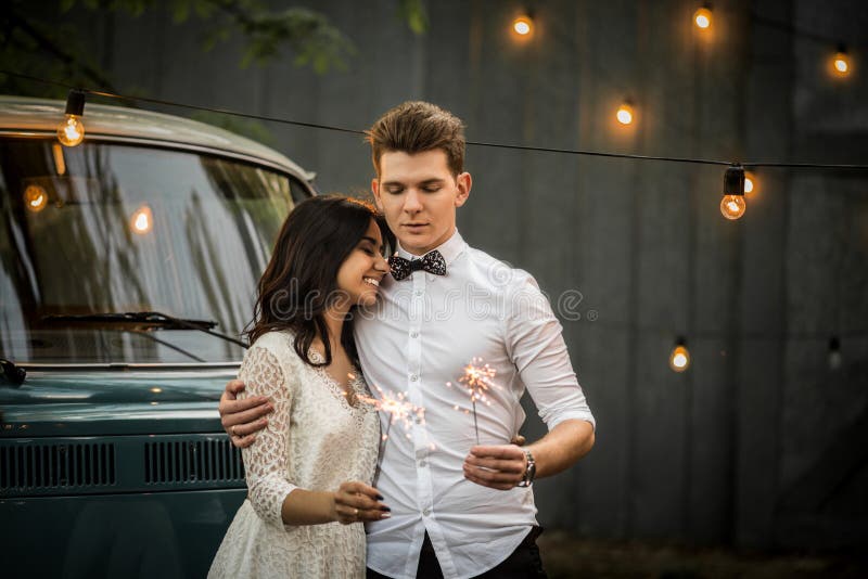 Wesoło szczęśliwi potomstwa dobierają się przytulenie blisko retro furgonetki Zakończenie zdjęcia stock Wesoło szczęśliwi potomstwa dobierają się przytulenie blisko retro furgonetki Zakończenie zdjęcia stock