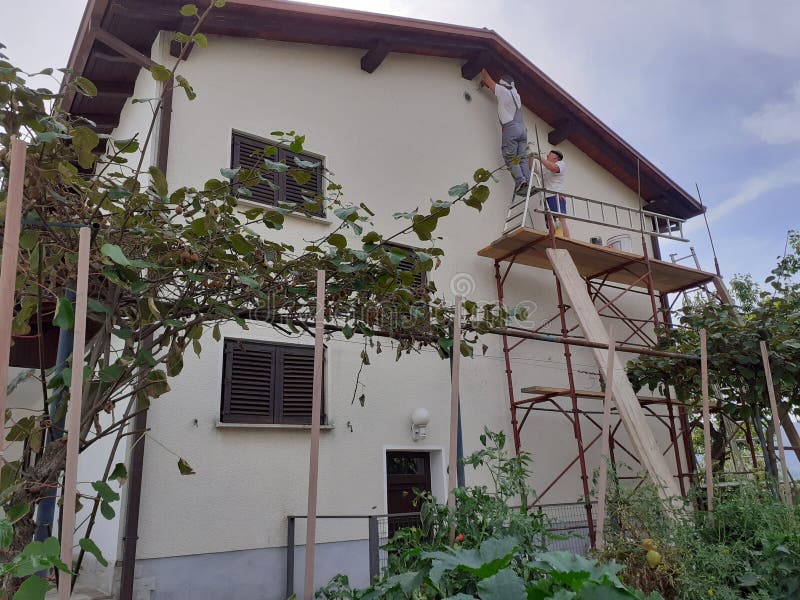 West facade of house undergoing renovation with painting in white facade colour