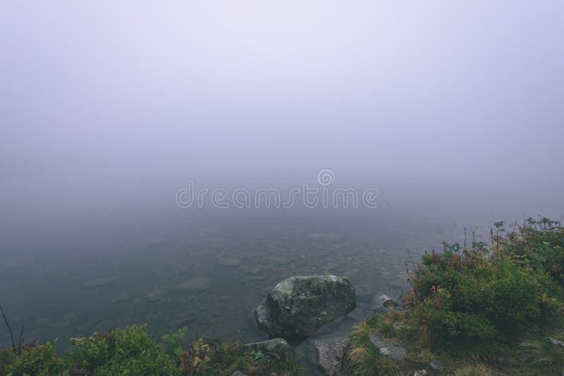Hmlisté ranné zobrazenie v mokrej horskej oblasti v slovenských Tatrách. panoráma horského jazera - vzhľad vintage filmu