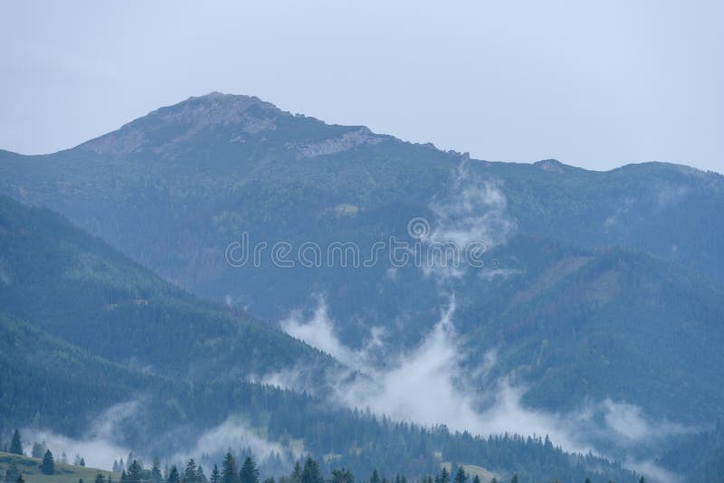 Mountain tops in autumn covered in mist or clouds