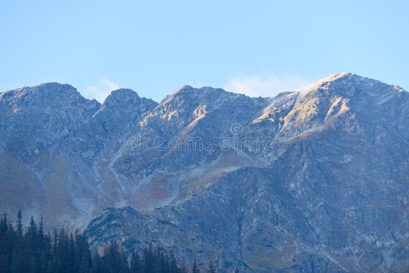 Mountain tops in autumn covered in mist or clouds in sunrise li