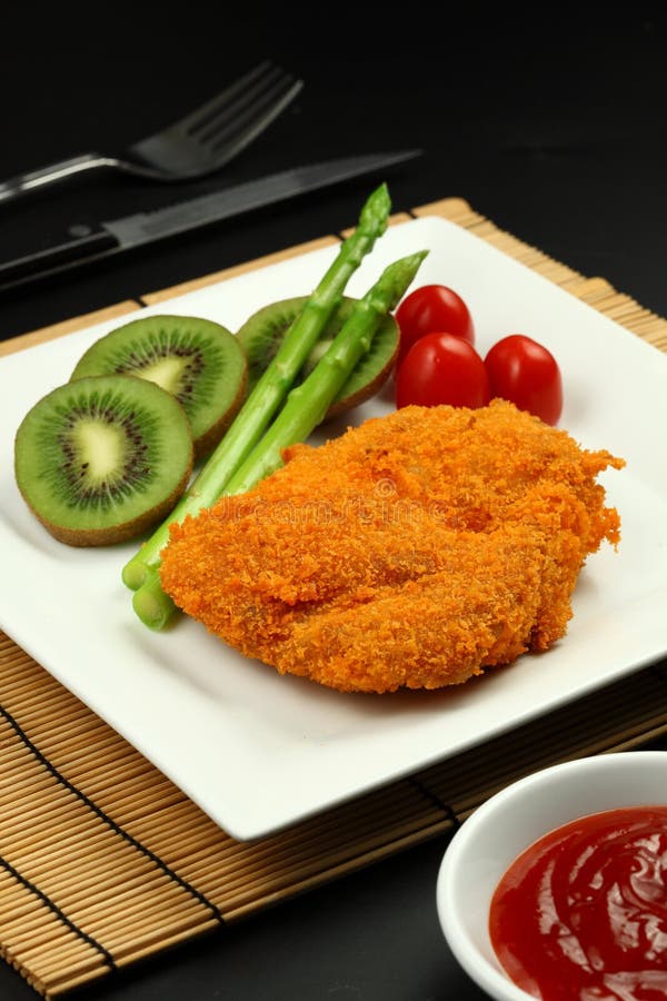 Fritto di pollo con kiwi, asparagi e pomodoro.