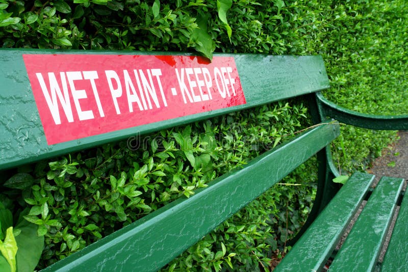 Park bench with wet paint sign.