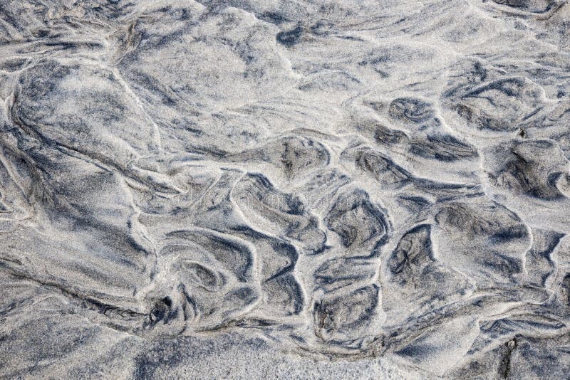 Grey and beige abstract background of wet sand texture formed by flowing water on beach. Grey and beige abstract background of wet sand texture formed by flowing water on beach