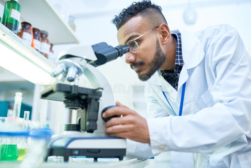 Wetenschapper die microscoop in laboratorium gebruikt