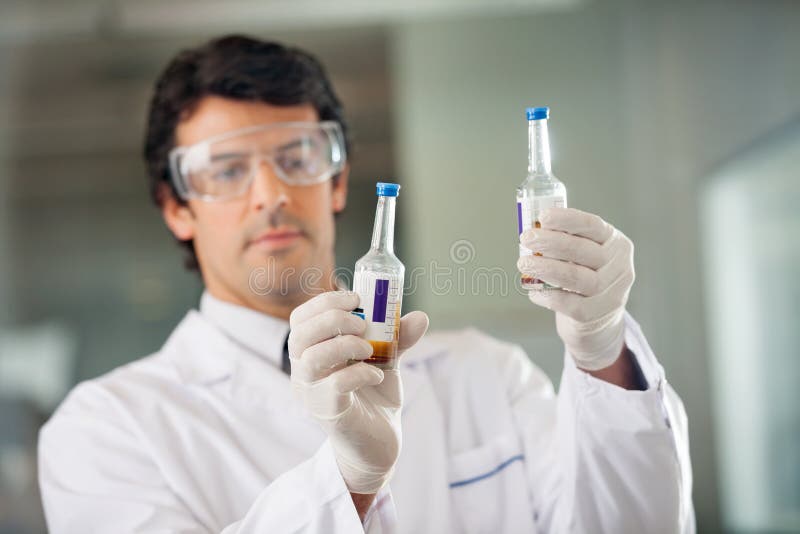 Wetenschapper onderzoekt urinemonsters in laboratorium stock foto's