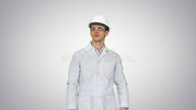 Wetenschapper ingenieur in white robe safety helm en bril die grappige bewegingen maakt met zijn ogen aan het eind op gradiënt